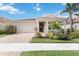 Inviting single-story home with a well-manicured lawn, brick driveway, and covered front entrance at 20389 Minuet Pl, Venice, FL 34293
