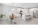 Eat-in kitchen with white cabinets, island with seating, stainless appliances and a nearby dining table at 20389 Minuet Pl, Venice, FL 34293