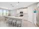 Stylish kitchen with white cabinets, stainless steel appliances, island and adjacent dining area at 20389 Minuet Pl, Venice, FL 34293