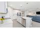 Open kitchen with white cabinetry, stainless appliances, and an island with seating overlooking the living area at 20389 Minuet Pl, Venice, FL 34293