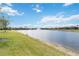 A picturesque lake with a fountain in a residential community with lush green grass at 20389 Minuet Pl, Venice, FL 34293