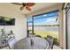 Enjoy picturesque lake views from this screened lanai with ceiling fan and comfortable seating at 20389 Minuet Pl, Venice, FL 34293