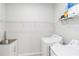 Bright laundry room features white washer and dryer, sink, cabinet, and wire shelving for ample storage at 20389 Minuet Pl, Venice, FL 34293