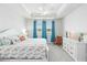 Light and airy main bedroom with a white tray ceiling, ceiling fan, and dresser at 20389 Minuet Pl, Venice, FL 34293