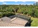 Aerial view of a home featuring a screened-in pool, tile roof, and a private backyard surrounded by mature trees at 2042 Mesic Hammock Way, Venice, FL 34292