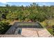 A picturesque aerial view of a home featuring a private pool, a screened-in enclosure, and lush landscaping at 2042 Mesic Hammock Way, Venice, FL 34292