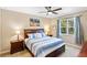 Comfortable bedroom with a large bed, ceiling fan, and a view of the lush outdoors at 2042 Mesic Hammock Way, Venice, FL 34292