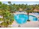 Beautiful pool with palm trees and ample seating at the community recreation center at 2042 Mesic Hammock Way, Venice, FL 34292