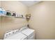 Functional laundry room equipped with a modern washer and dryer, plus ample shelving for storage at 2042 Mesic Hammock Way, Venice, FL 34292
