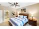 Cozy main bedroom with a ceiling fan, wood furnishings and decor, and an adjacent bathroom at 2042 Mesic Hammock Way, Venice, FL 34292