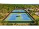 Aerial view of community tennis courts surrounded by lush greenery and mature trees at 2042 Mesic Hammock Way, Venice, FL 34292