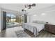 Main bedroom features a ceiling fan, wood floors, and sliding glass doors leading to the screened lanai at 2114 S Biscayne Dr, North Port, FL 34287