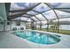 Enjoy this private in-ground screened pool, perfect for relaxation and recreation with palm tree landscaping at 2114 S Biscayne Dr, North Port, FL 34287