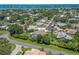 Picturesque aerial view of a neighborhood highlighting beautifully landscaped yards, a community pond, and well-built homes at 213 Bayside Ct, Nokomis, FL 34275