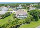 Home with a screened pool, lush backyard, and landscaping in a residential neighborhood from above at 213 Bayside Ct, Nokomis, FL 34275