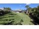 Large backyard with lush landscaping, manicured lawn, screened lanai, and a partial view of the home's exterior at 213 Bayside Ct, Nokomis, FL 34275