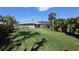 Expansive backyard with lush, green lawn, mature landscaping, and a screened lanai perfect for outdoor living at 213 Bayside Ct, Nokomis, FL 34275