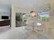 Bright breakfast nook with white table and chairs, tile floor and sliding glass doors to a screened lanai at 213 Bayside Ct, Nokomis, FL 34275