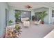 Inviting covered patio featuring comfortable seating, lush plants, and a ceiling fan at 213 Bayside Ct, Nokomis, FL 34275