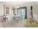 Bright dining room with a round table, four chairs, elegant lighting, and large framed artwork at 213 Bayside Ct, Nokomis, FL 34275
