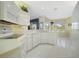 Well-lit kitchen with white cabinets, appliances, tile floors and sunny breakfast nook with views to the backyard at 213 Bayside Ct, Nokomis, FL 34275