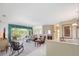 Spacious living room featuring neutral carpet, a ceiling fan, and seamless transition to the dining area at 213 Bayside Ct, Nokomis, FL 34275