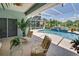 Screened-in pool area with a relaxing seating area and views of tropical foliage at 213 Bayside Ct, Nokomis, FL 34275