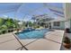 Stunning screened-in pool with clear blue water, surrounded by lush landscaping and comfortable lounge area at 213 Bayside Ct, Nokomis, FL 34275