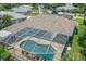 Aerial view of a screened-in pool and patio area, with mature landscaping and a tidy backyard at 213 Bayside Ct, Nokomis, FL 34275