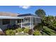 Screened-in pool area with a covered patio surrounded by tropical plants and landscaped garden at 213 Bayside Ct, Nokomis, FL 34275