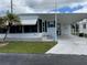 Charming white mobile home with covered parking, well-maintained lawn, and a lovely palm tree at 218 Palm Air Dr, Osprey, FL 34229