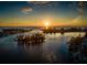 Aerial view of boats sailing in the bay waters during a vibrant sunset, showcasing waterfront living and serene beauty at 229 San Marco Dr, Venice, FL 34285