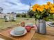 Outdoor dining on wood table with yellow flowers, overlooking a beautiful backyard at 229 San Marco Dr, Venice, FL 34285