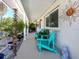 Inviting covered front porch with bright blue Adirondack chairs and decorative sun art at 229 San Marco Dr, Venice, FL 34285