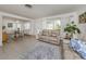 Spacious living room with neutral-toned furniture, tile flooring, and access to the dining area at 229 San Marco Dr, Venice, FL 34285
