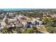 An aerial view capturing the neighborhood streets and houses, with lush trees and the beautiful beach in the background at 236 Harbor S Dr # 202, Venice, FL 34285