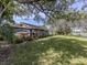Back exterior featuring a lanai with large windows, a well-maintained lawn, and mature trees near a pond at 268 Southampton Dr # 309, Venice, FL 34293