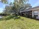 Back exterior view of a home featuring a large lanai, lush lawn, and serene water views at 268 Southampton Dr # 309, Venice, FL 34293