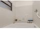 Clean, white tiled tub and shower area in bathroom with safety bar and convenient storage at 268 Southampton Dr # 309, Venice, FL 34293