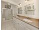 Bathroom featuring double sinks, granite countertops, white cabinets, and a glass walk-in shower at 268 Southampton Dr # 309, Venice, FL 34293