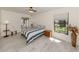 Cozy bedroom features a large window, light wood floors and a striped bedspread at 268 Southampton Dr # 309, Venice, FL 34293