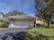 Charming home exterior featuring a two-car garage, neutral paint, and lush landscaping at 268 Southampton Dr # 309, Venice, FL 34293