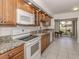 Bright kitchen featuring granite countertops, modern appliances, and view of the backyard pond at 268 Southampton Dr # 309, Venice, FL 34293