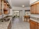 Beautiful open kitchen with granite counters, tile floors, and a view of the backyard pond at 268 Southampton Dr # 309, Venice, FL 34293