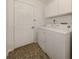 Functional laundry room with a washer, dryer, storage cabinets, and durable tiled floor at 268 Southampton Dr # 309, Venice, FL 34293