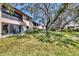 Scenic backyard with lush green grass and mature trees offering shade and privacy at 275 Mission W Trl # G, Venice, FL 34285