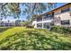 Scenic backyard view with a pond, lush green grass, mature trees, and lots of shade and privacy at 275 Mission W Trl # G, Venice, FL 34285