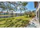 Scenic backyard view with a pond, lush green grass, mature trees, shade, and privacy at 275 Mission W Trl # G, Venice, FL 34285