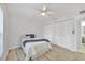 Bright bedroom featuring wood-look flooring, ceiling fan, and double-door closet at 275 Mission W Trl # G, Venice, FL 34285