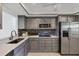 Well-appointed kitchen featuring modern appliances, elegant gray cabinetry, and a clean, contemporary design at 275 Mission W Trl # G, Venice, FL 34285